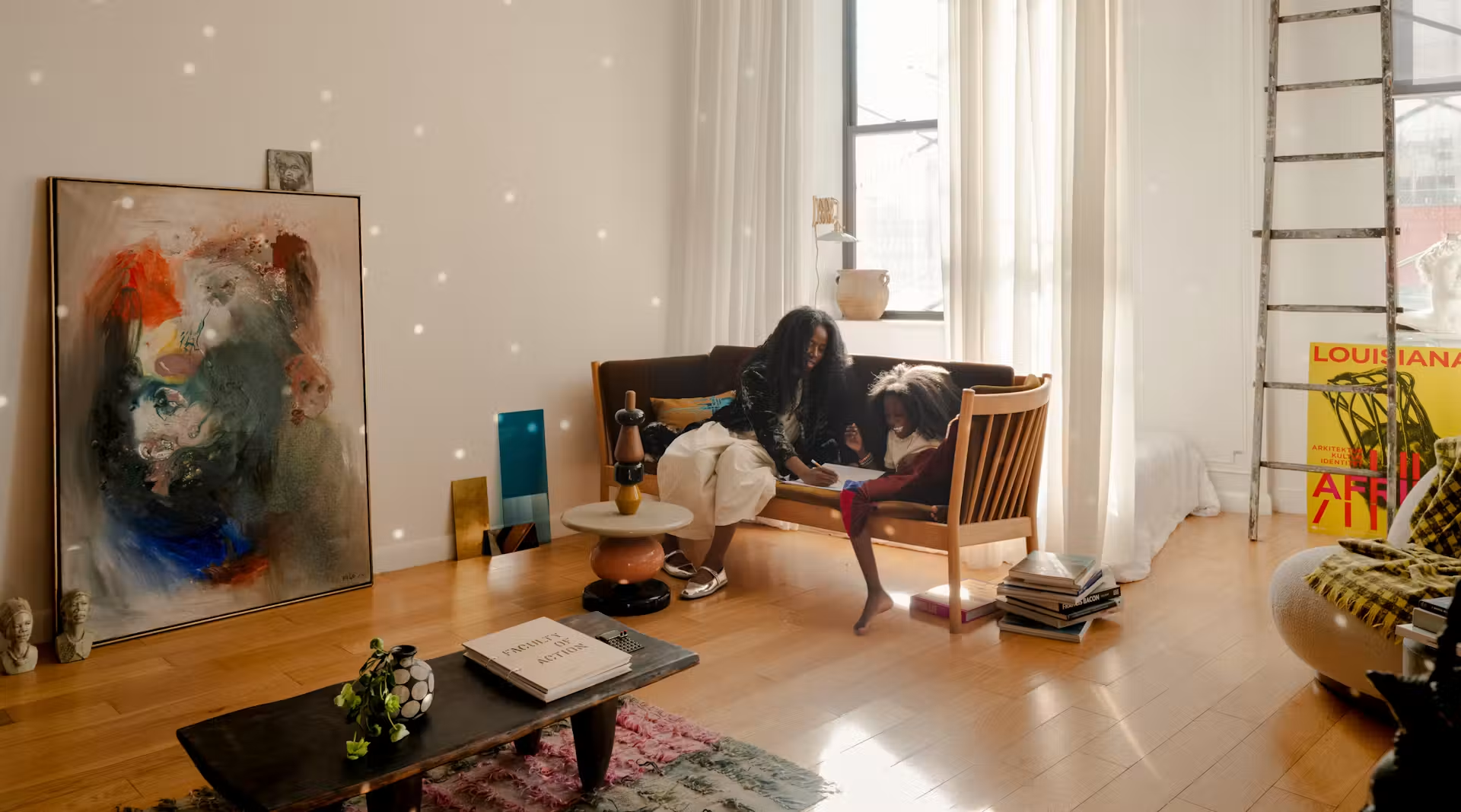 A mother and two children reading together in their sunlit Brooklyn loft